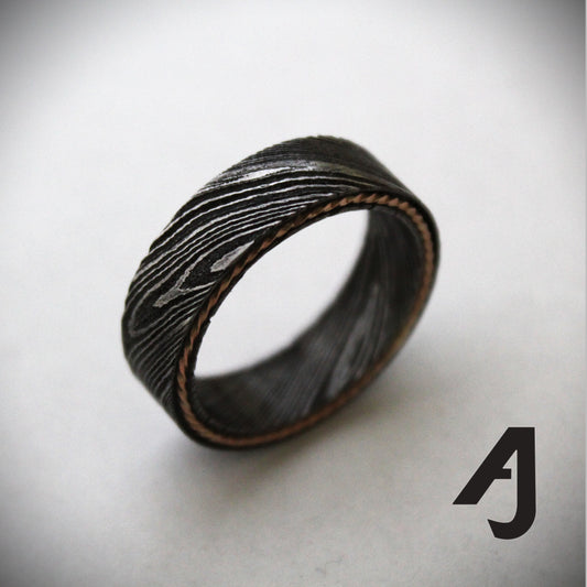 Damascus steel ring with a twisted rose gold inlay, showcasing unique wavy patterns and a blend of rugged durability with elegant warmth