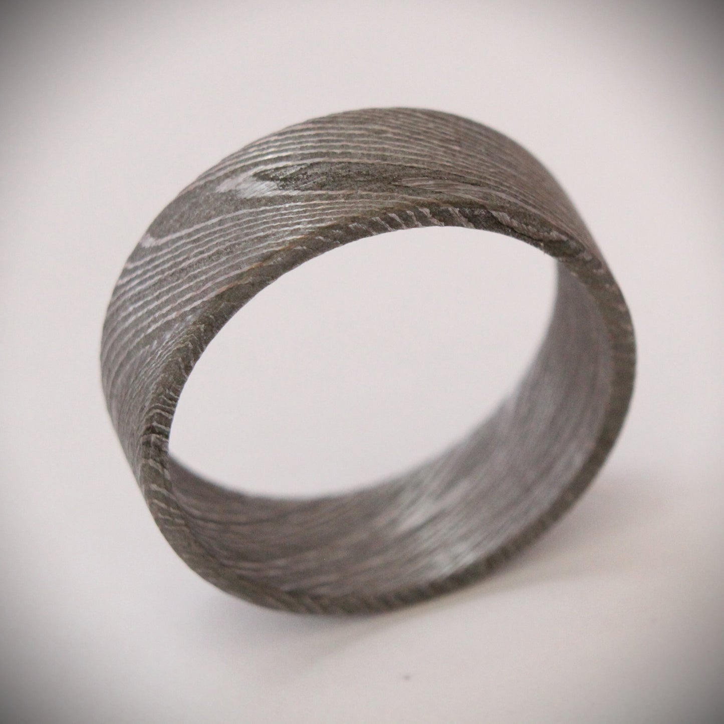 Stunning 9mm Damascus steel ring featuring unique, flowing patterns and exceptional strength. A bold, rugged piece of jewelry that exudes elegance and individuality, perfect as a wedding band, engagement ring, or statement accessory.