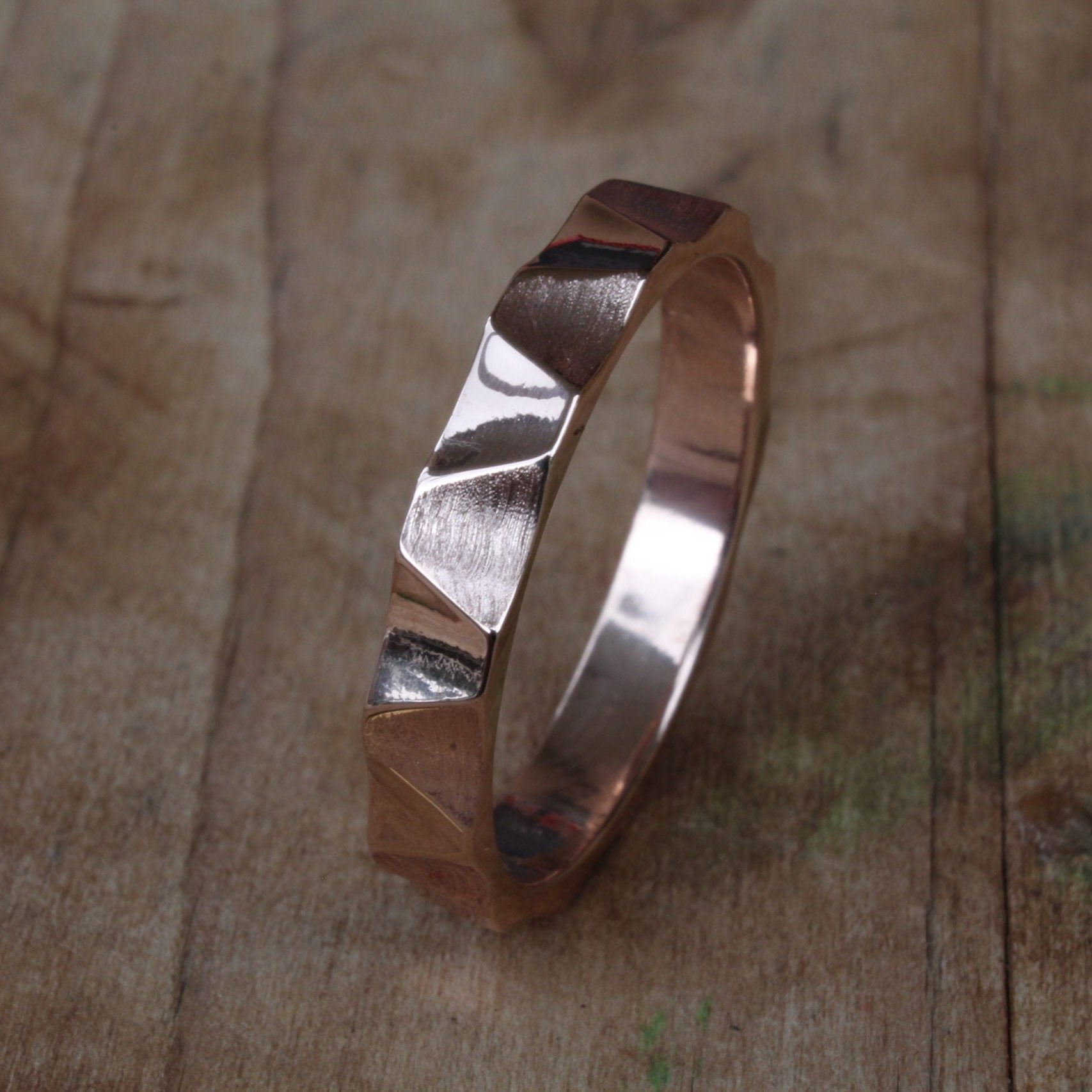 18ct rose/pink gold ring with an internally smooth, rounded band for a comfortable fit. The exterior features a dynamic waving angular pattern. The warm pink hue of the rose gold adds elegance, while the modern pattern offers a contemporary touch.